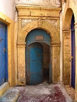 photo d’une porte entrebâillée au fond d’une impasse à Essaouira