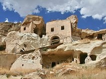 photo du village de Çavusin incrusté dans une falaise